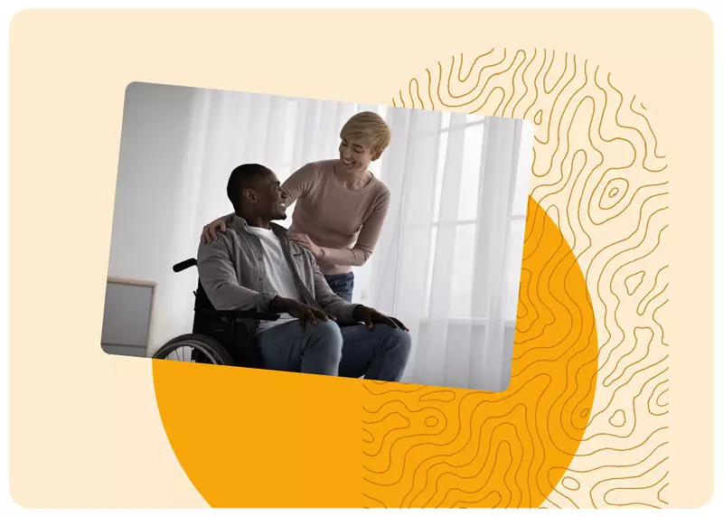 Un homme en fauteuil roulant accompagné d'une assistante souriante dans un cadre lumineux, illustrant l'accompagnement humain et personnalisé de Gérez Zen après un accident de la vie.